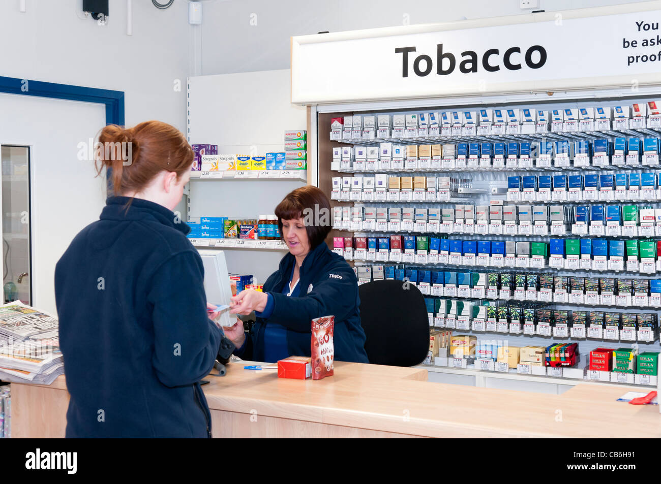 tesco express cigarettes Woman is served in a Tesco petrol station Stock Photo