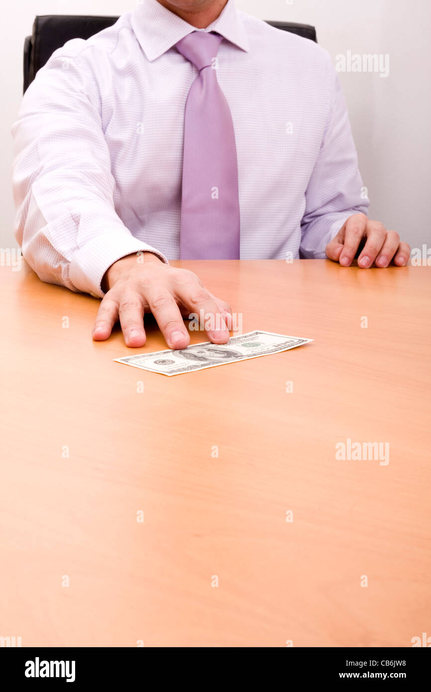 businessman grabbing a dollar bill in his desk (selective focus Stock