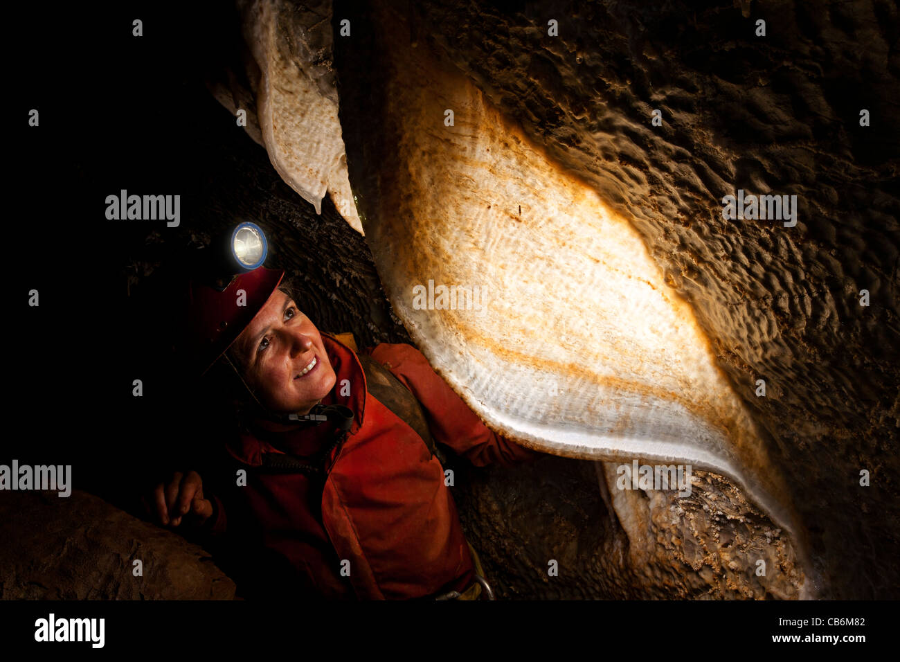 Female caver with stalactite curtain in French cave Stock Photo