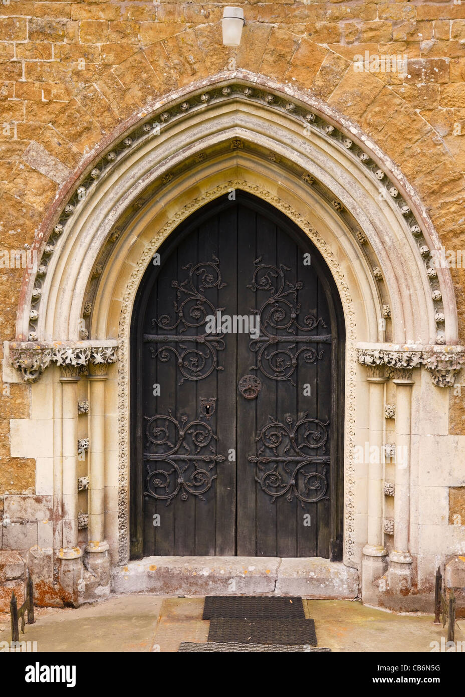 Ornate pointed Gothic arch church door with fleuron decorated hinges St James Church, Little Dalby, Leicestershire, England, UK Stock Photo