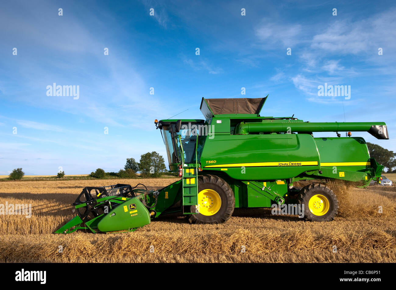 Harvesting barley with John Deere T560 combine. Stock Photo