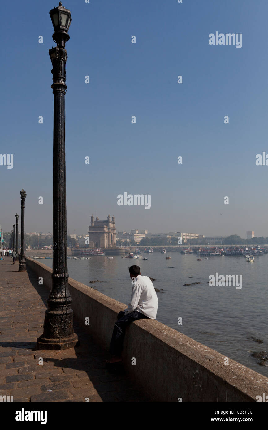 man rests near Gateway to India Stock Photo