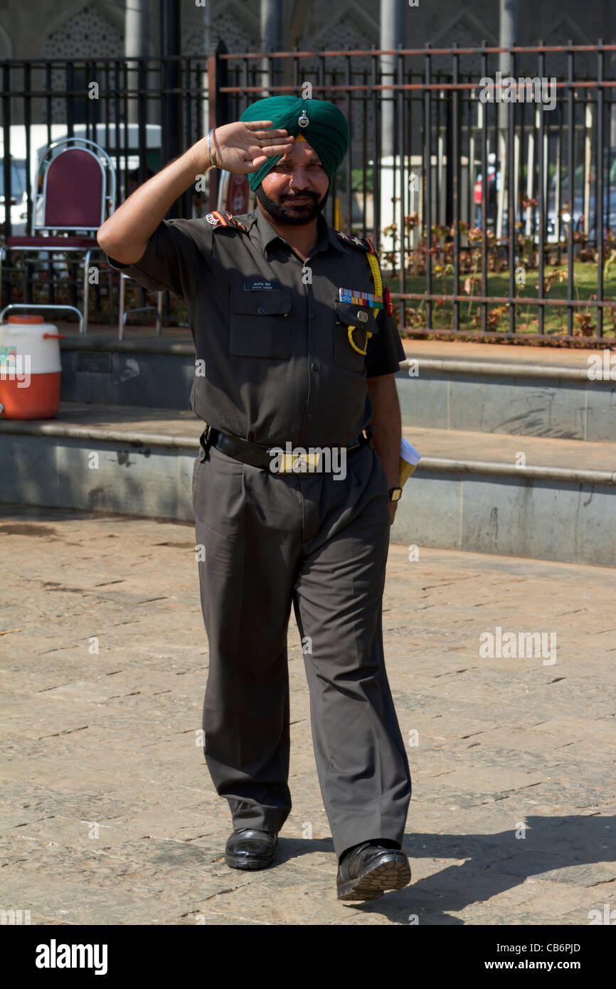 Sikh guard in turban salutes outside gateway to India Stock Photo