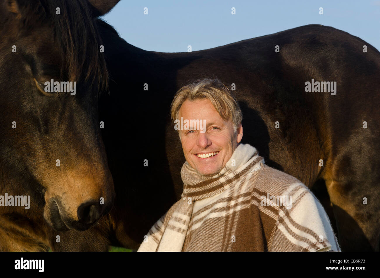 A happy smiling blonde man with his horse Stock Photo - Alamy