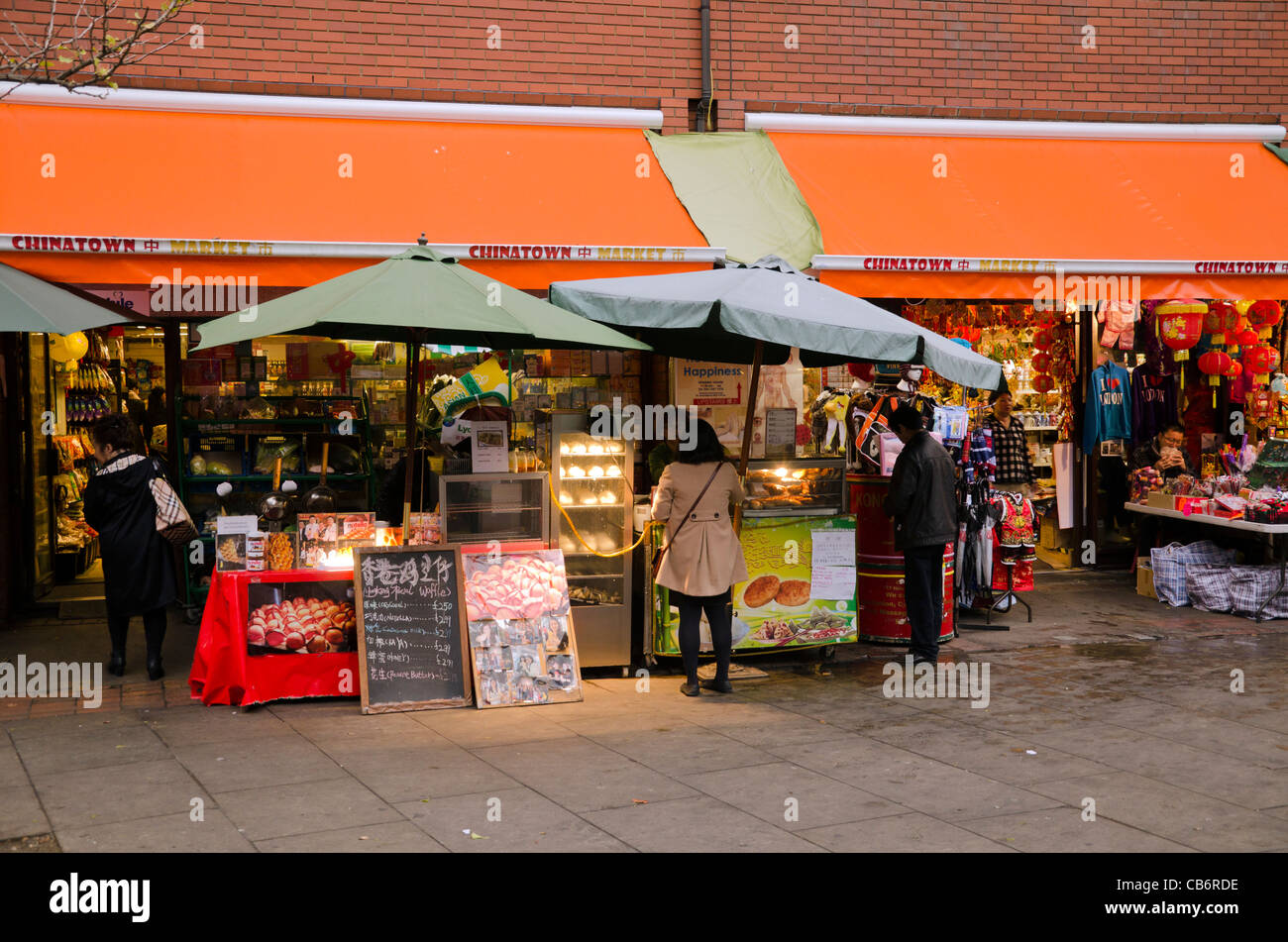 Chinese people shopping at small shops in Chinatown Central London UK Stock Photo