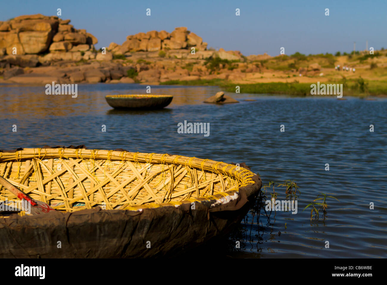 hampi ruins rocks water coracle river transport Stock Photo