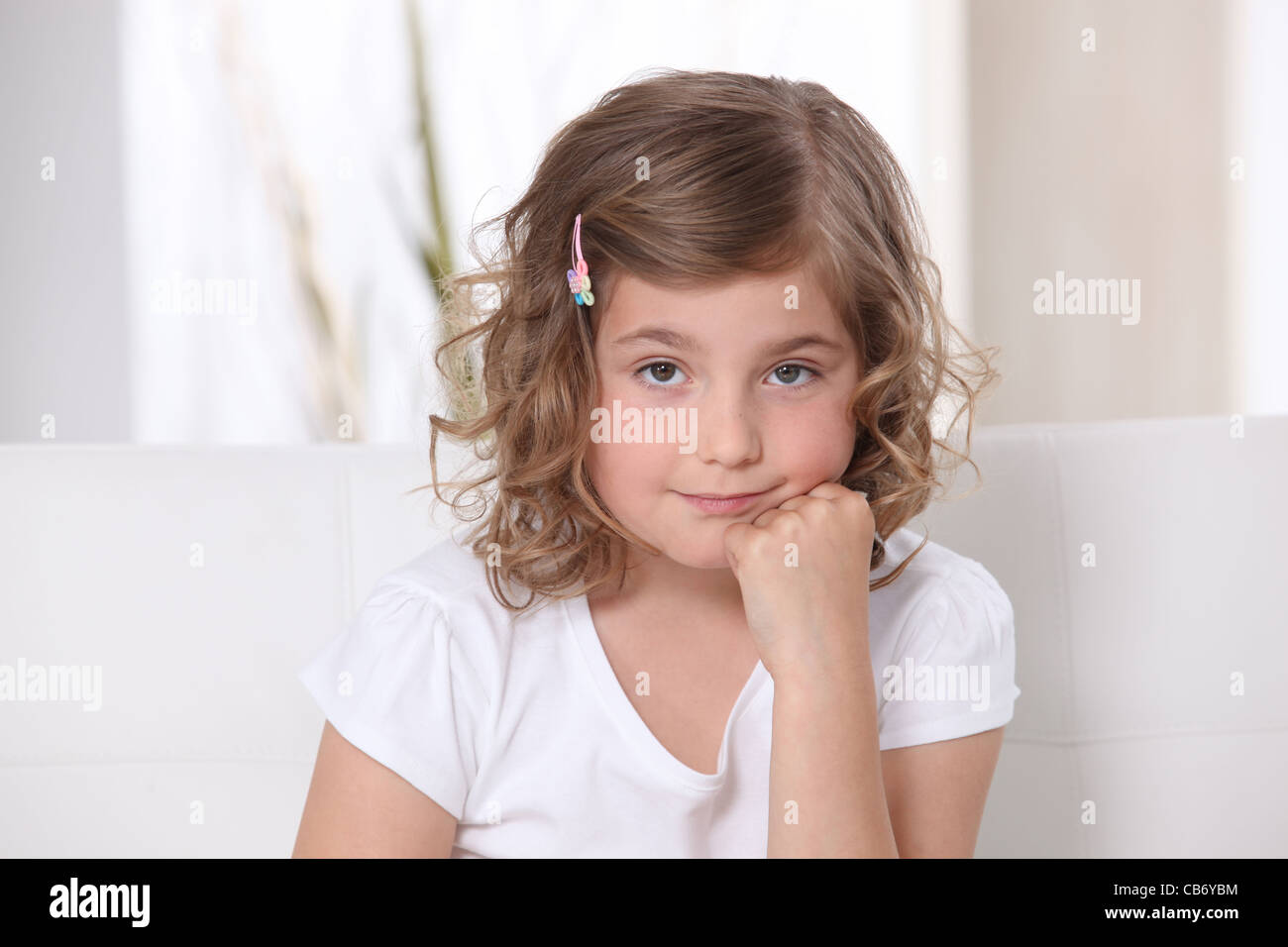 Young girl sitting on a sofa Stock Photo - Alamy