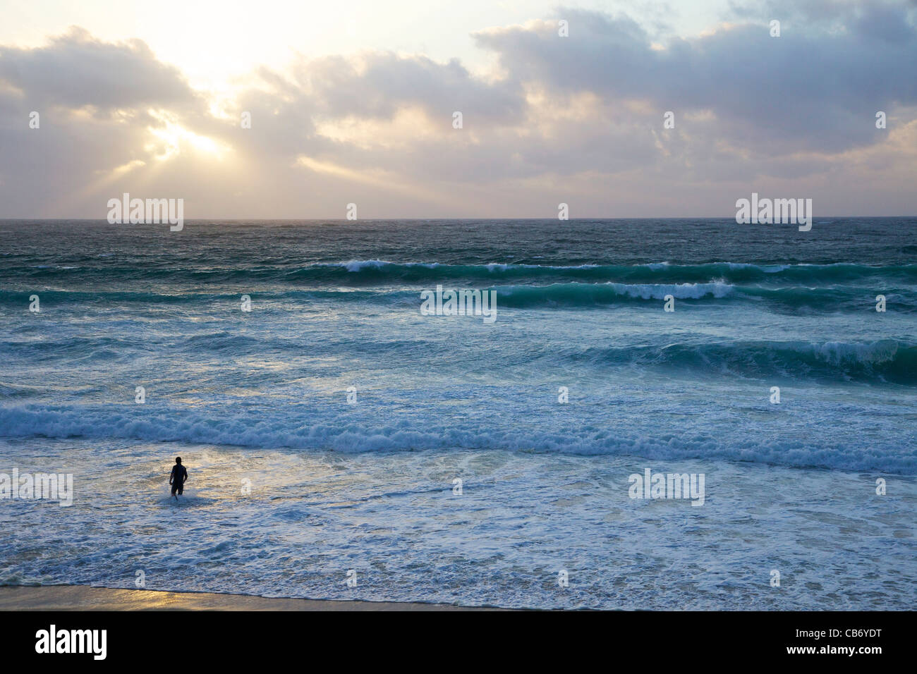 Lone surfer in rough seas off Porthmeor beach in evening sun, St Ives, Cornwall, Southwest England, UK, United Kingdom, GB, Stock Photo