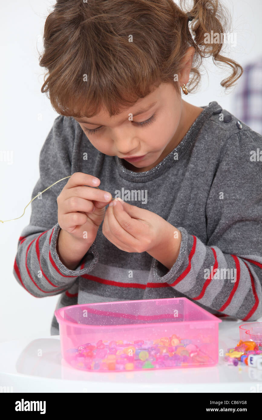 adorable little girl making necklace Stock Photo Alamy