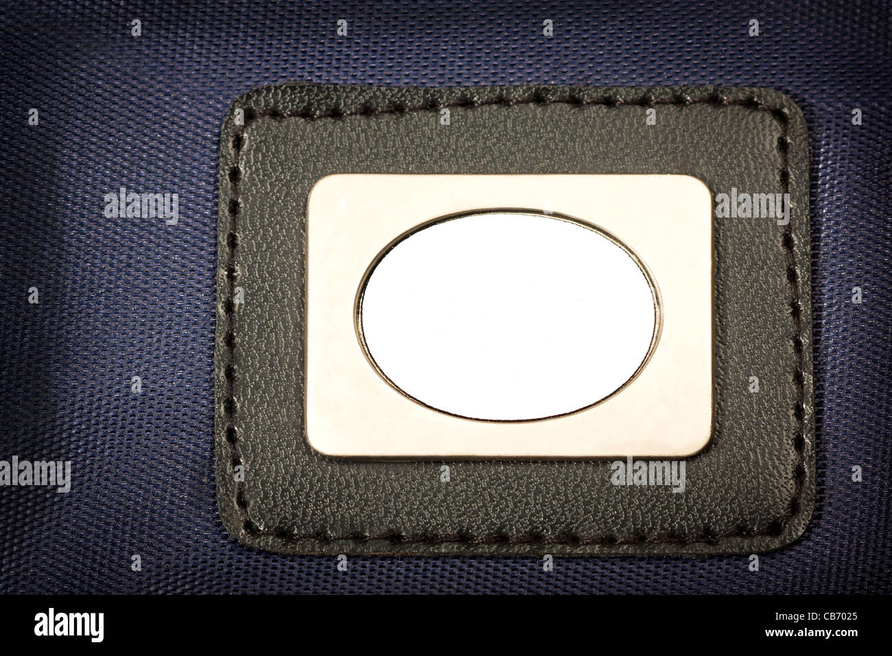 Metal Plate, with black border  inserted in blue fabric Stock Photo