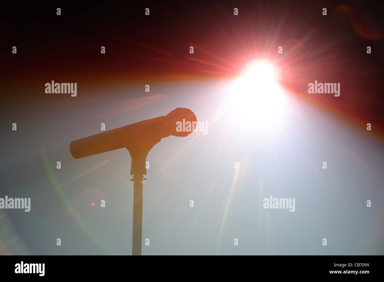 Spot lit microphone and stand on an empty stage Stock Photo