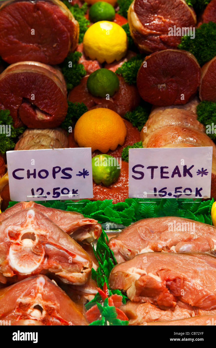 Photo of raw cuts of meat in a butchers shop including beef and veal steaks, chops and joints. Stock Photo