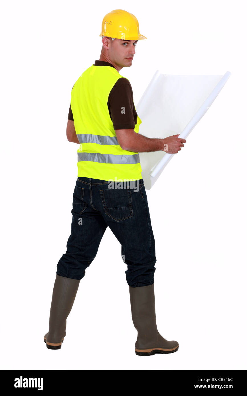 Tradesman looking at a blueprint Stock Photo - Alamy