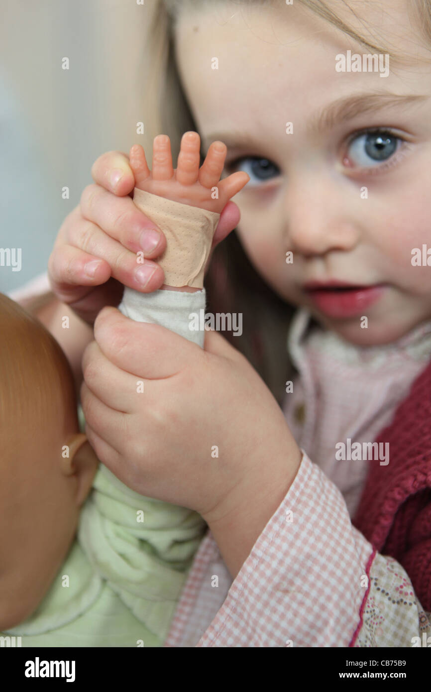 Little girl playing with doll Stock Photo - Alamy