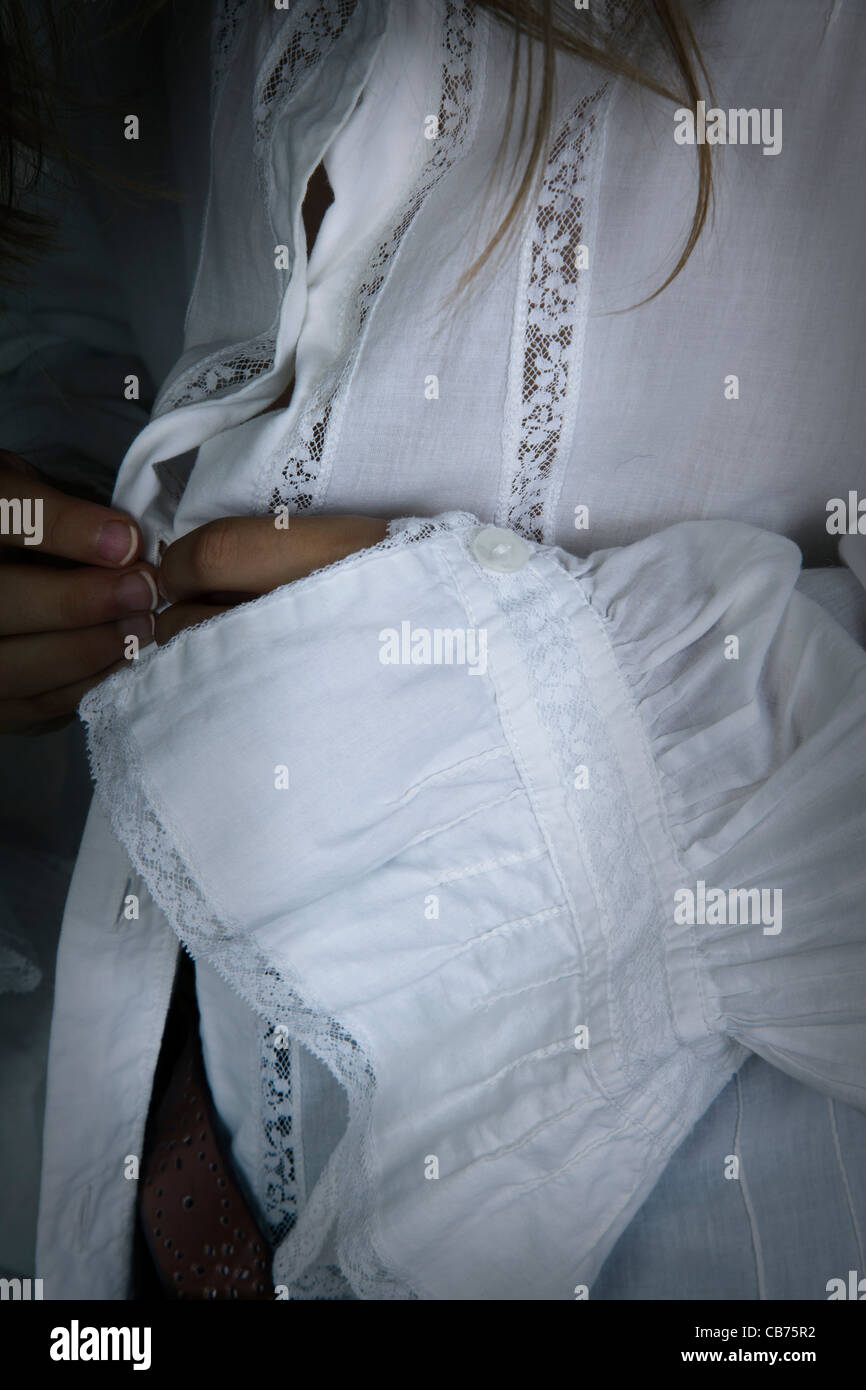 Close Up Of Girl Fastening White Lace Shirt Stock Photo