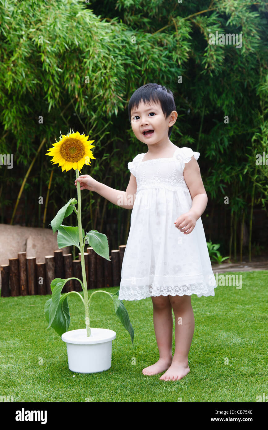 Little girl with a sunflower Stock Photo - Alamy