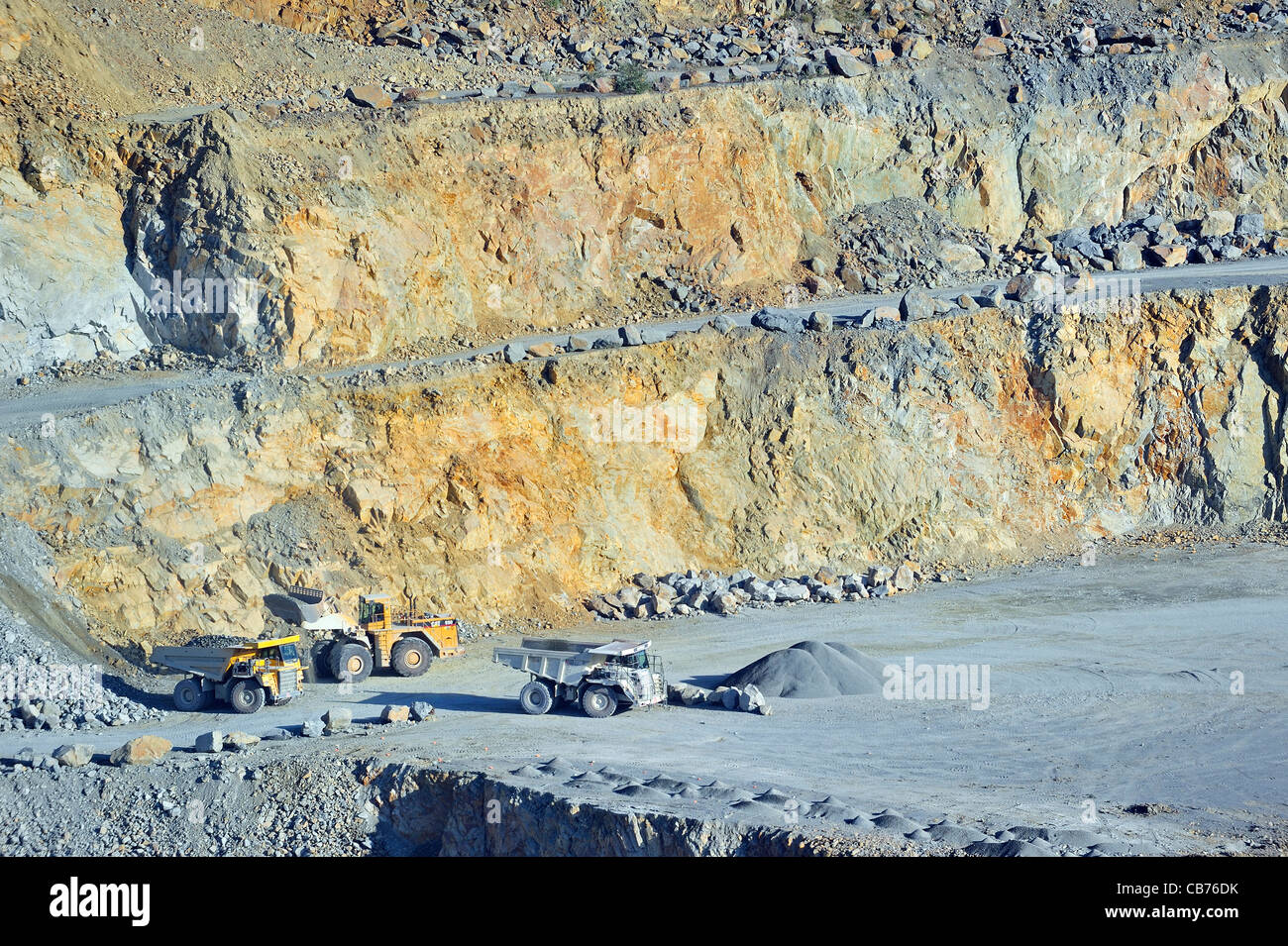 Trucks at work in porphyry quarry, open-pit mine for the production of gravel for road building at Lessen / Lessines, Belgium Stock Photo