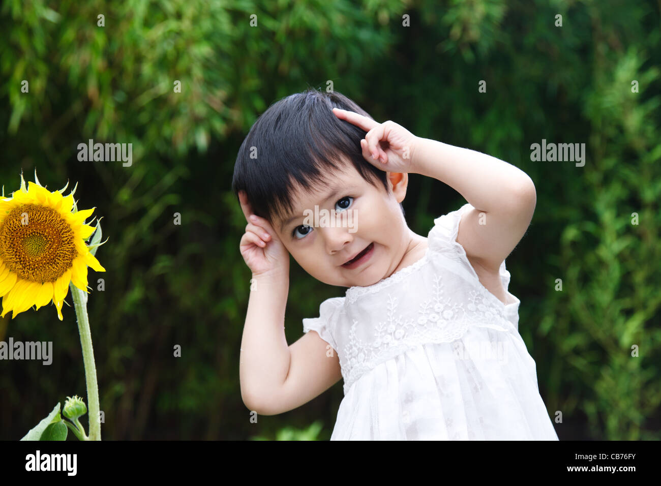 Little girl with a sunflower Stock Photo - Alamy