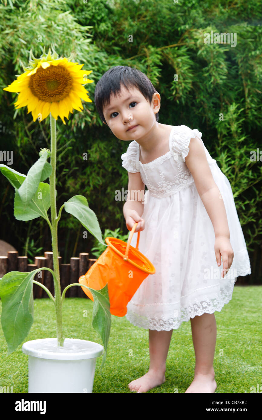 Little girl with a sunflower Stock Photo - Alamy