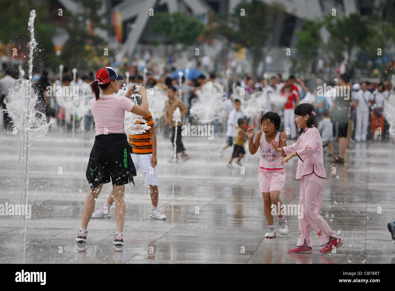 Beijing, China: Chinese couples, families and kids enjoy the vast plazas outside the National Stadium during Paralympics 2008 Stock Photo