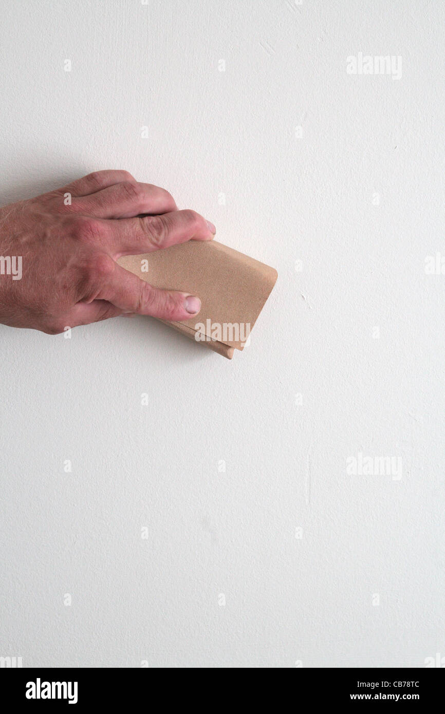 Caucasian Male Sanding Down an Internal Wall MODEL RELEASED Stock Photo