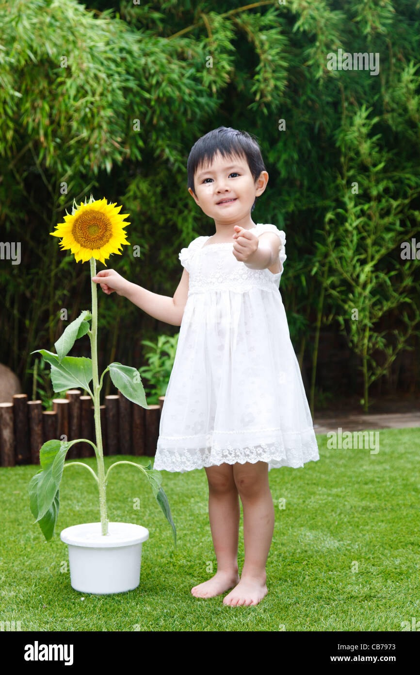 Little girl with a sunflower Stock Photo - Alamy