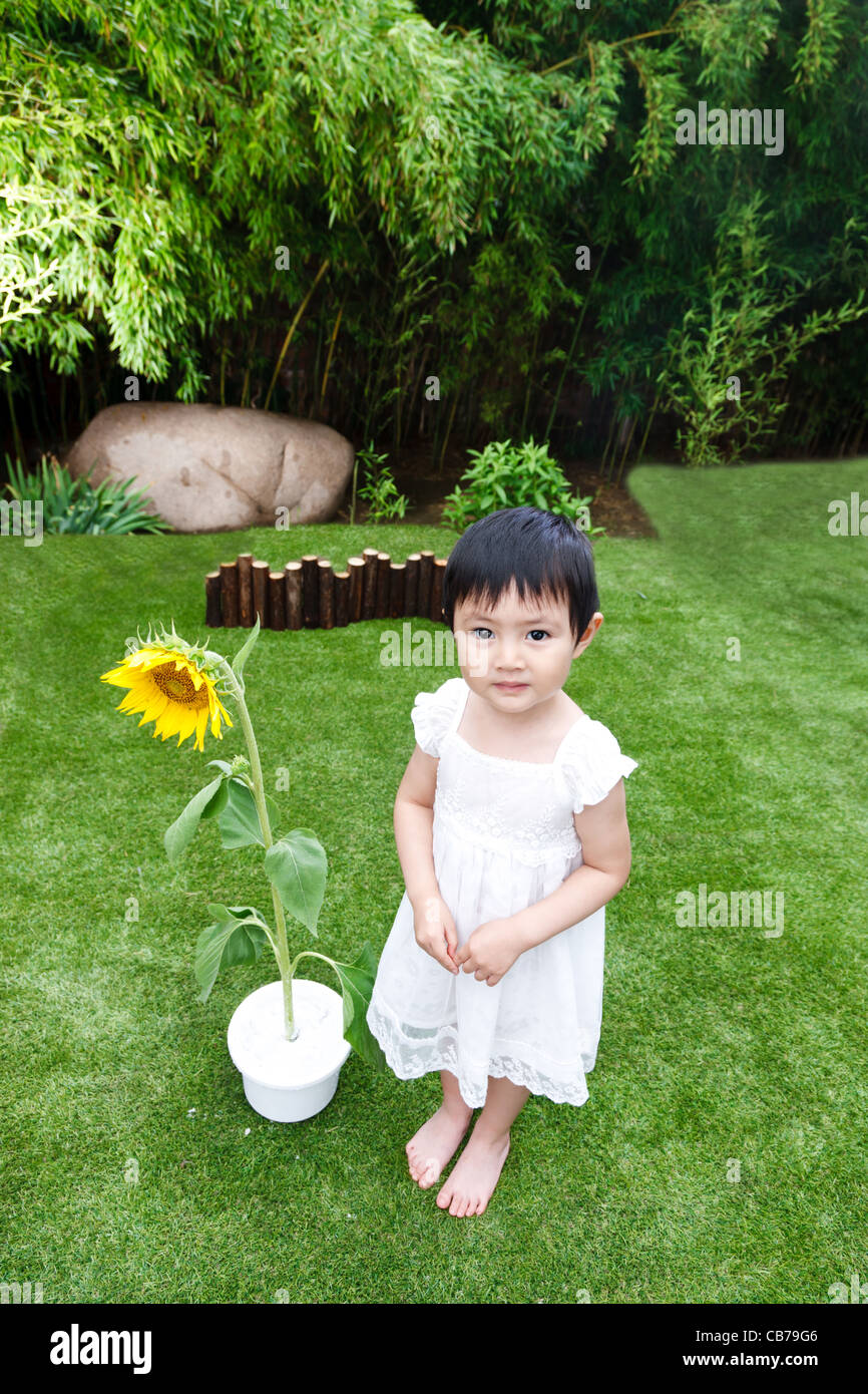 Little girl with a sunflower Stock Photo - Alamy