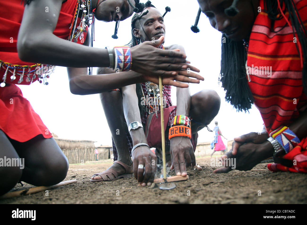 Young Masai men start a friction fire by rubbing two sticks together at their village in the Masai Mara National Reserve, Kenya. 2/2/2009. Photograph: Stock Photo