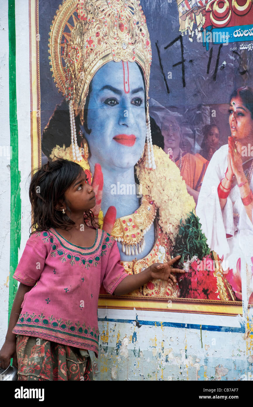 Poor Indian nomadic beggar girl standing in front of a Rama movie poster on  an indian street. Andhra Pradesh, India Stock Photo - Alamy