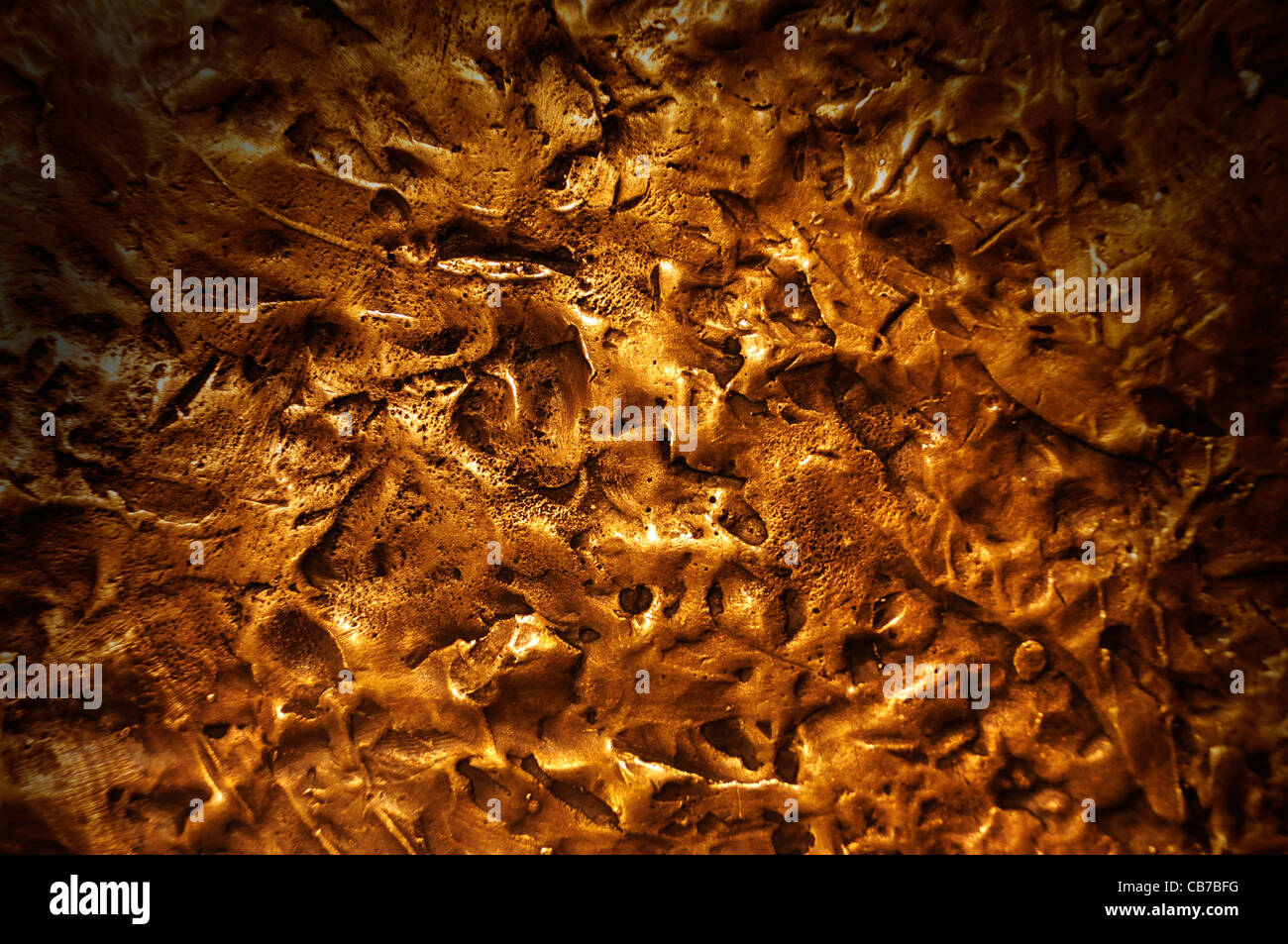 Close-up on a bronze surface texture lit dramatically from above Stock Photo