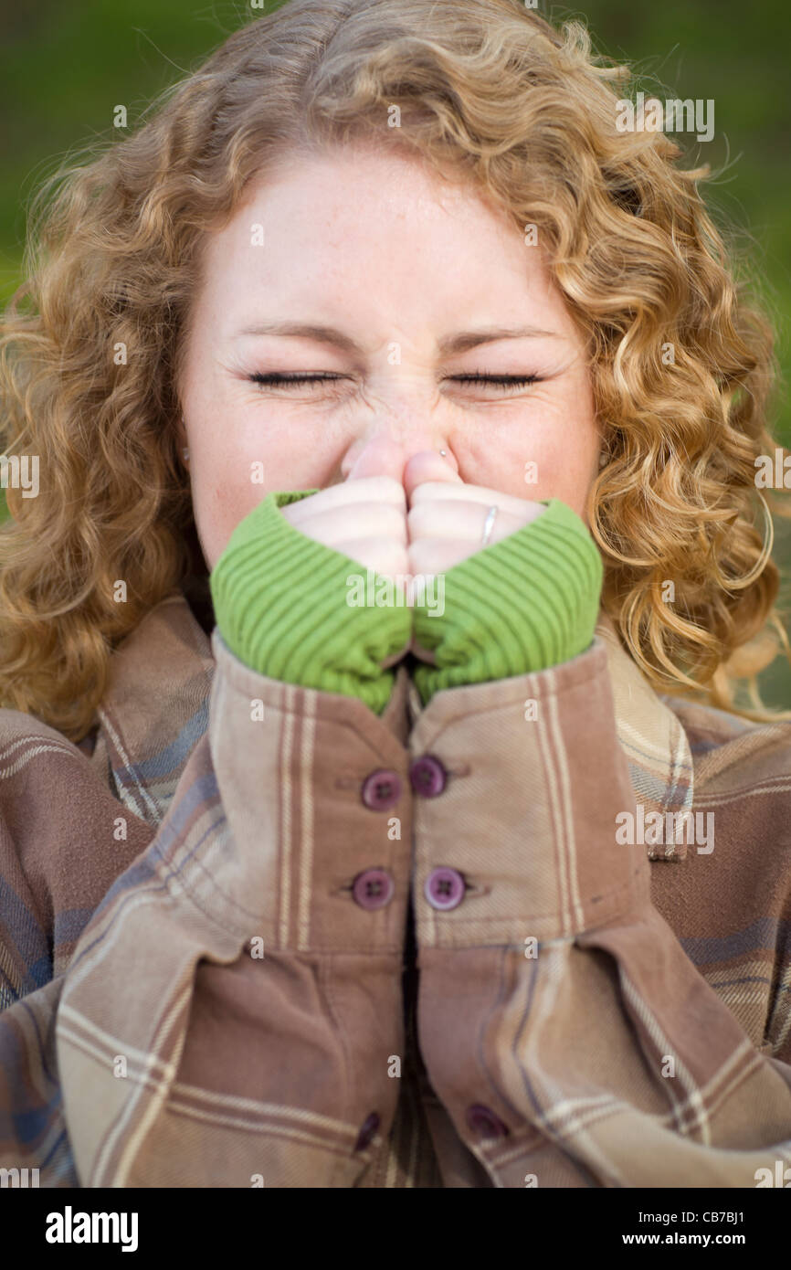Pretty Young Teen with Cold/Flu Sneezing Outdoors. Stock Photo