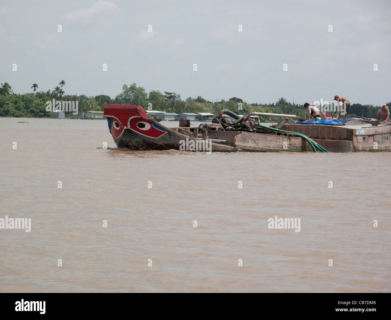 Boat dredging up sand from the Mekong River in the Mekong Delta, Vietnam Stock Photo