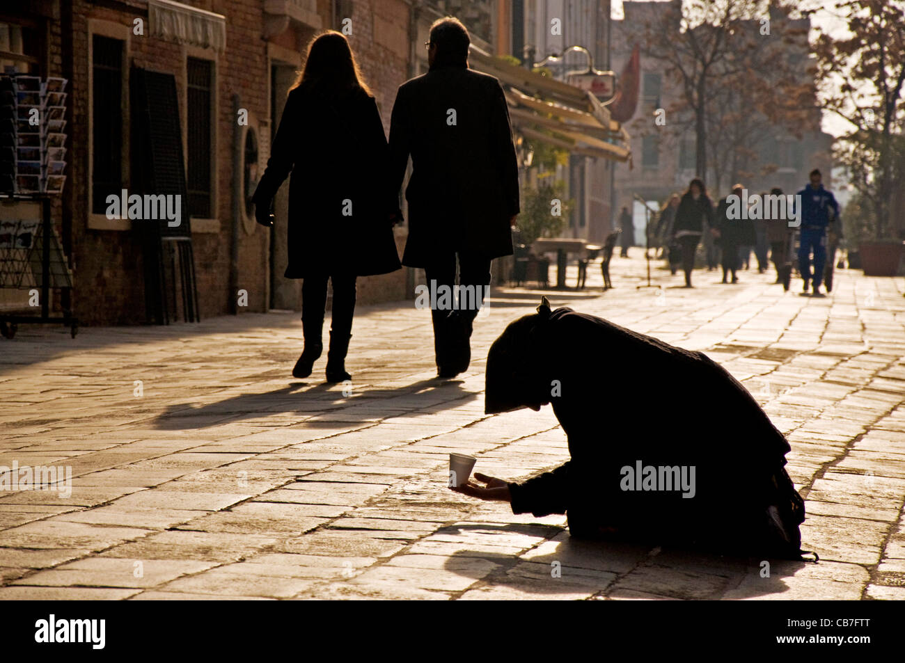 Woman begs on street in Venice Stock Photo