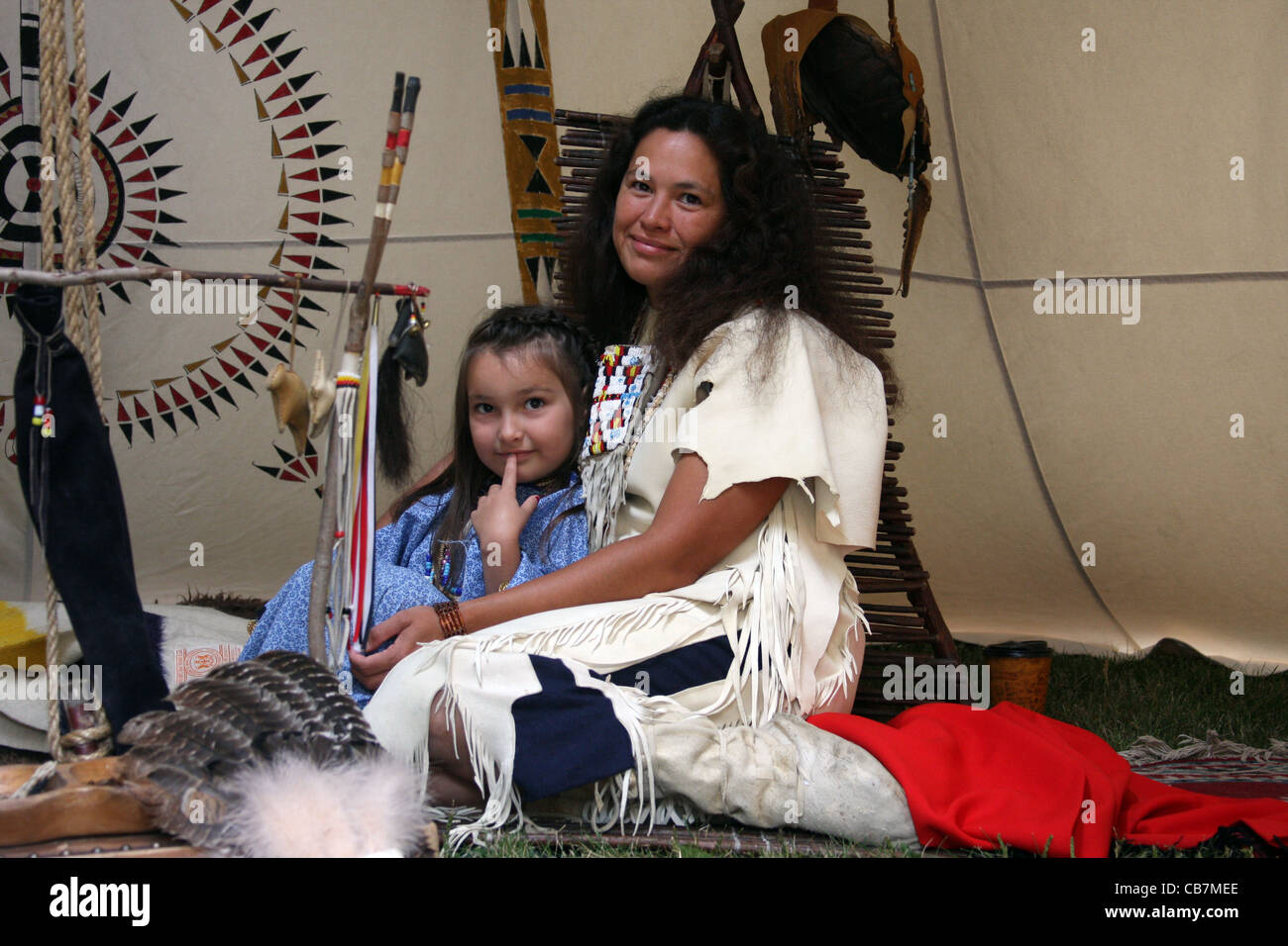 A Native American Indian woman and child sitting in a tipi Stock Photo