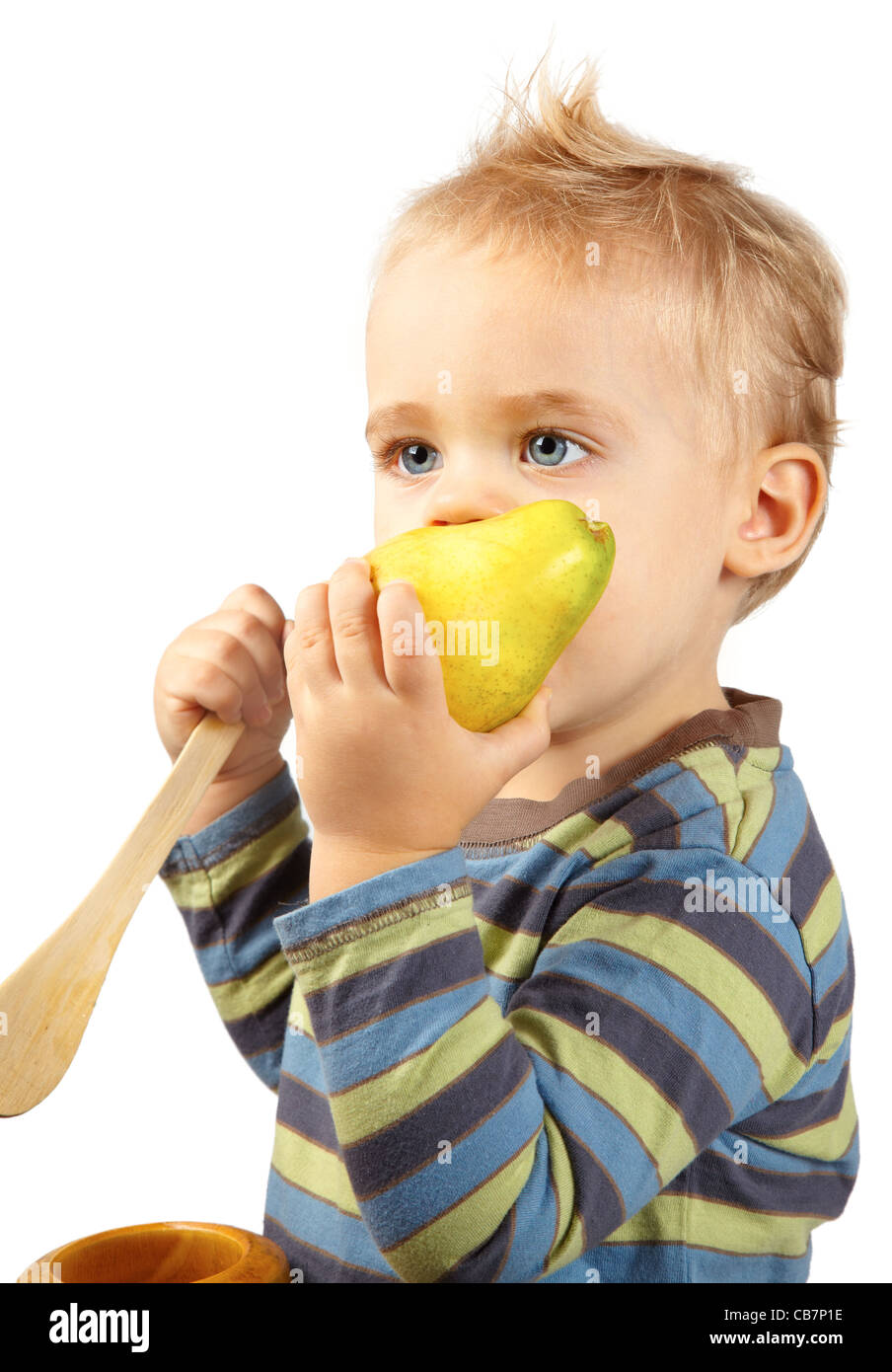 Studio portrait of one year old baby boy eating a ripe pear on white. Stock Photo