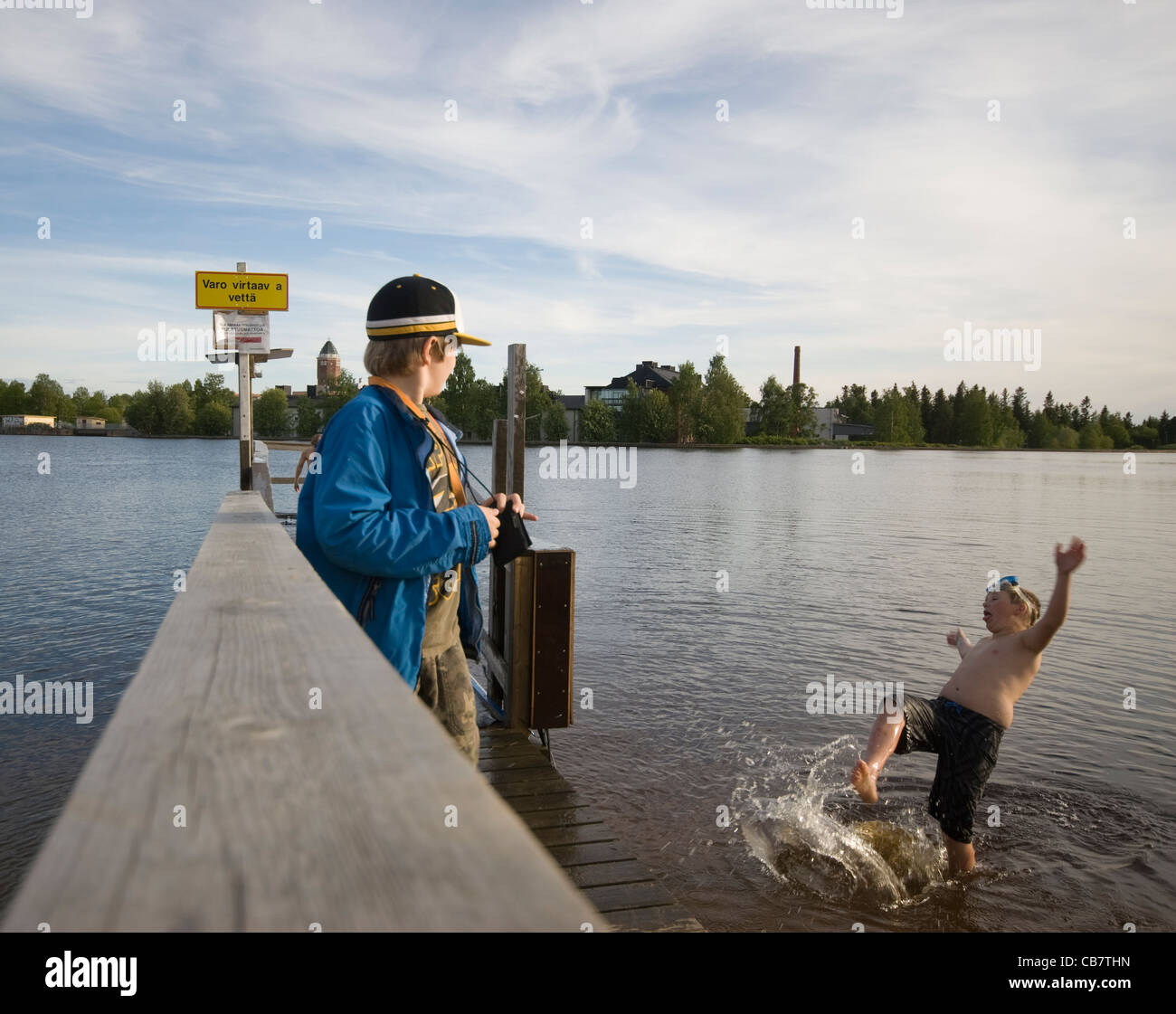 Two boys swimming and playing in the river Oulu, in Oulu, Finland Stock
