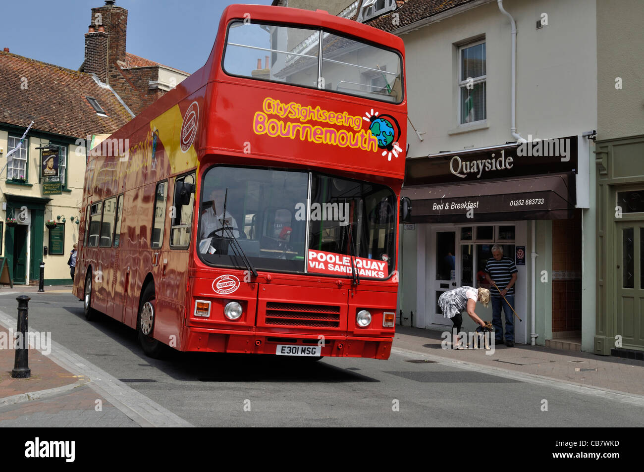An open top sightseeing bus negotiates the lower part of Poole High Street, Dorset Stock Photo