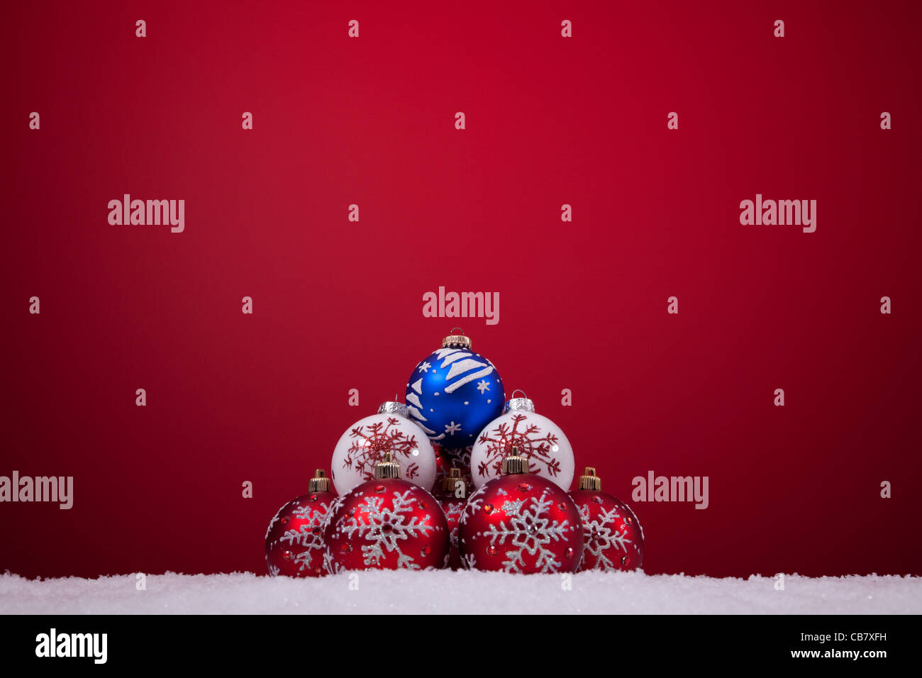 christmas colorful balls over the snow with a red background (selective ...