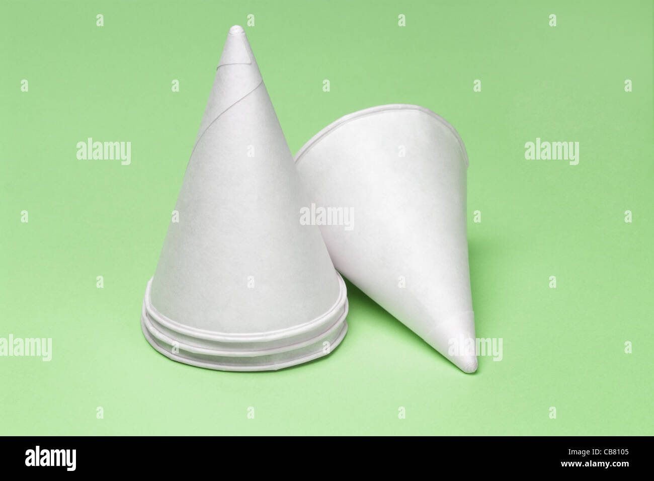 Cone shape disposable paper cups on green background Stock Photo