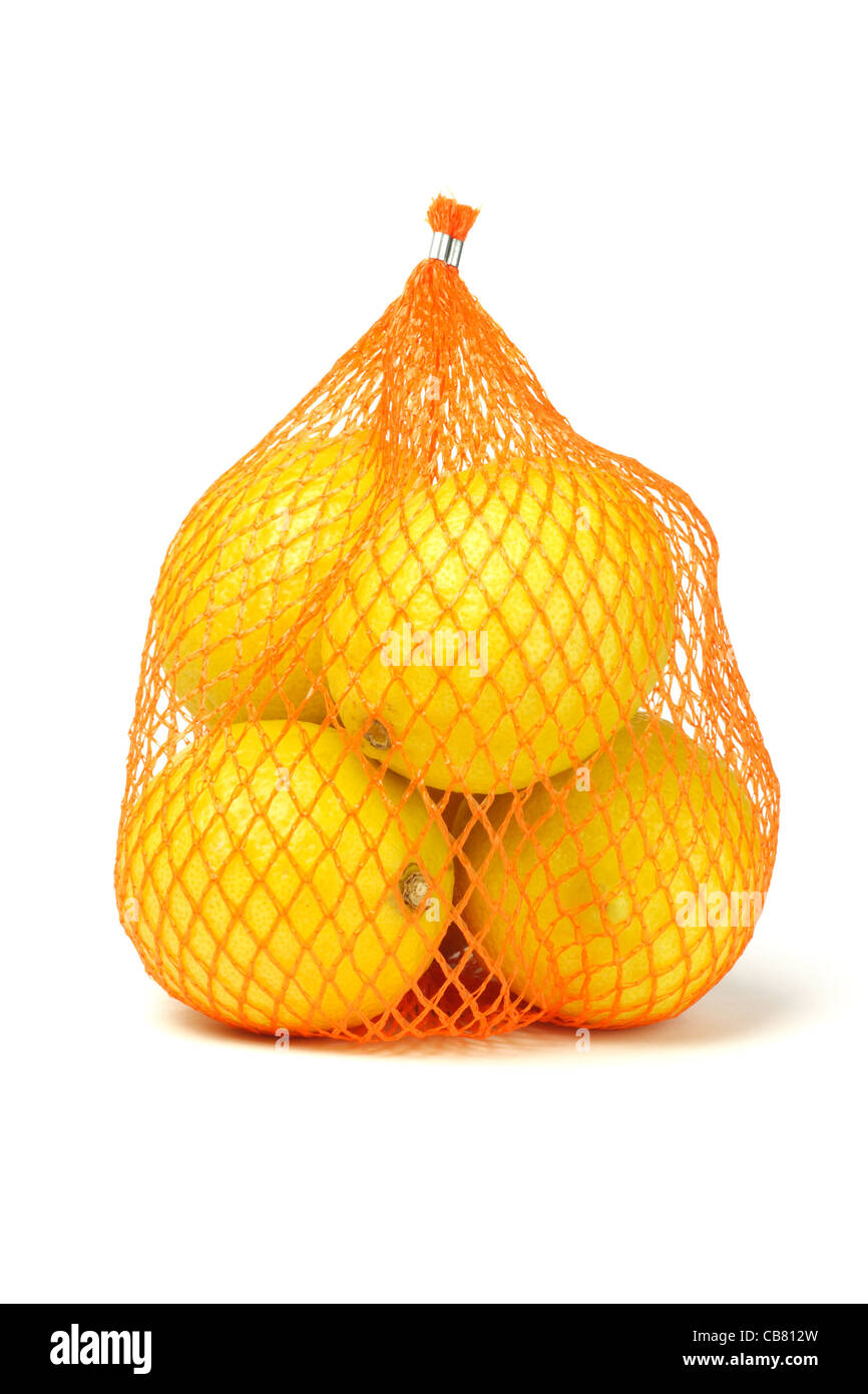 Fresh lemons in plastic netting sack on white background Stock Photo