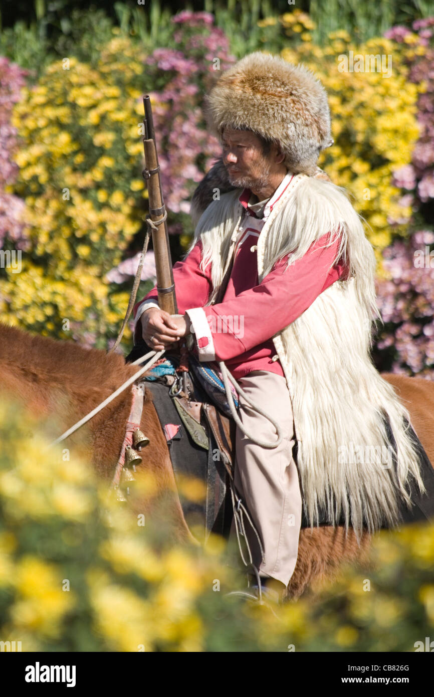 China Yunnan Lijiang Mongol horseman surrounded by flowers Stock Photo