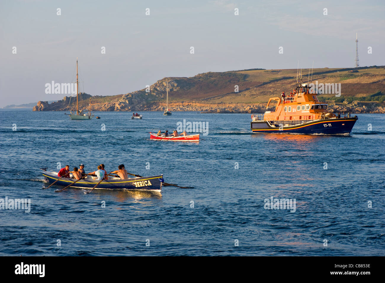 Gig Racing on the Isles of Scilly, Uk with Lifeboat in the distance. Stock Photo