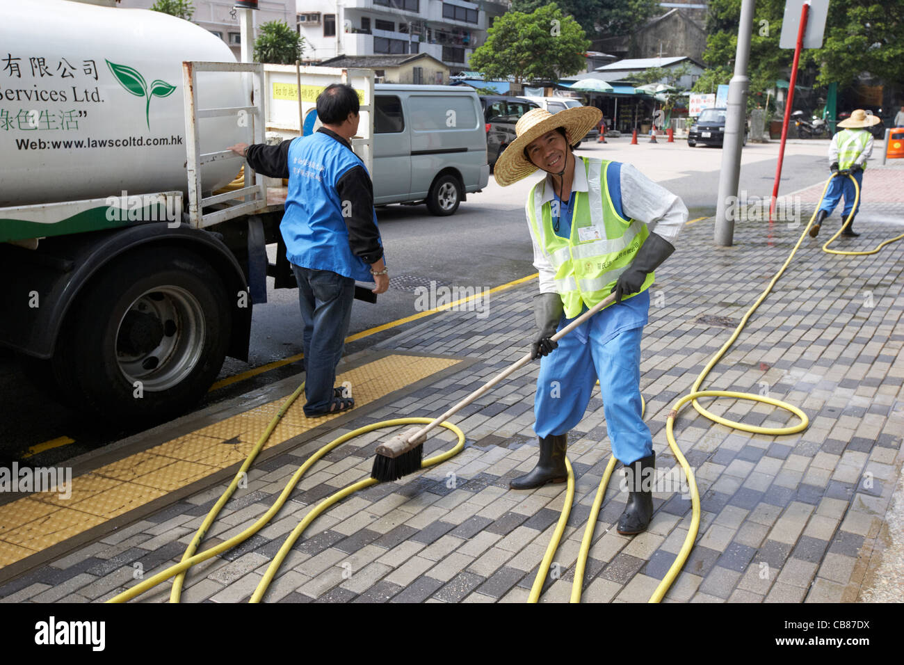 chinese worker cleaning the streets pavement in urban sha tin, hong