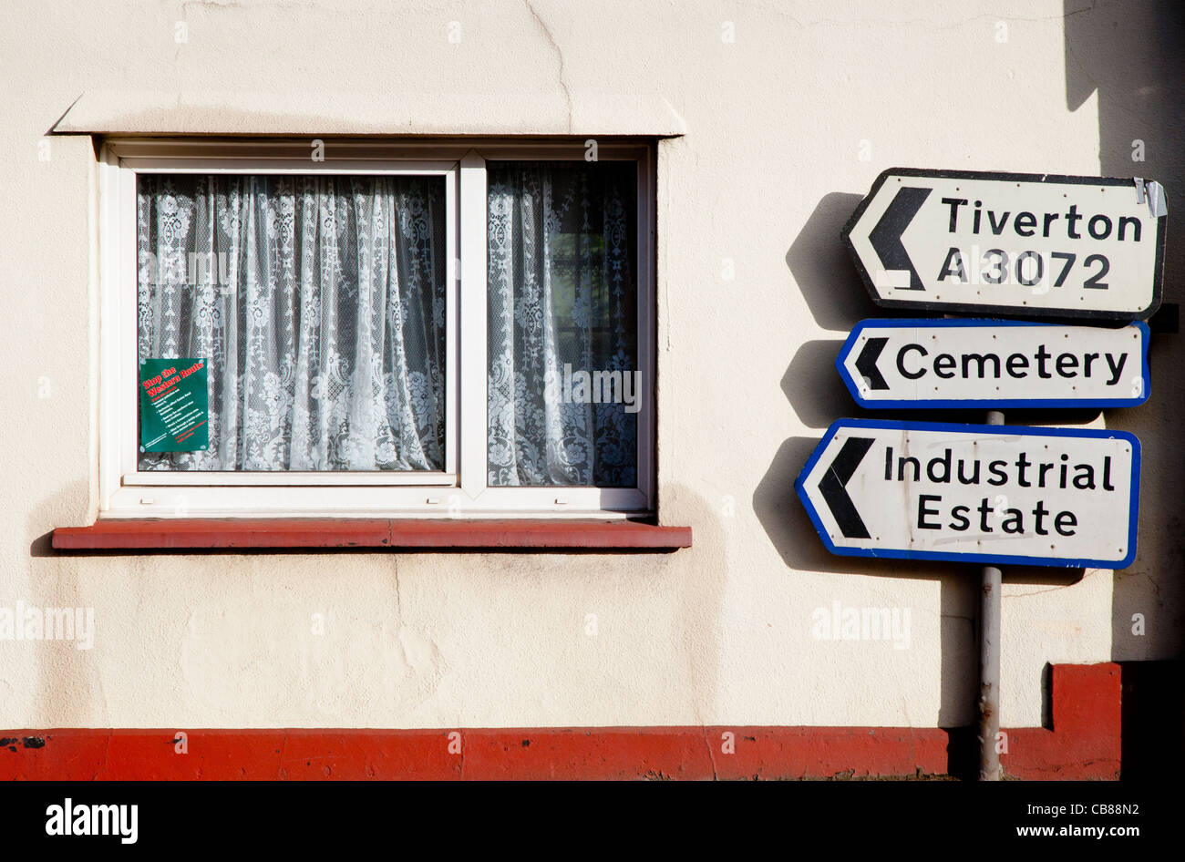 House window and direction sign pointing to Tiverton, Cemetery and ...