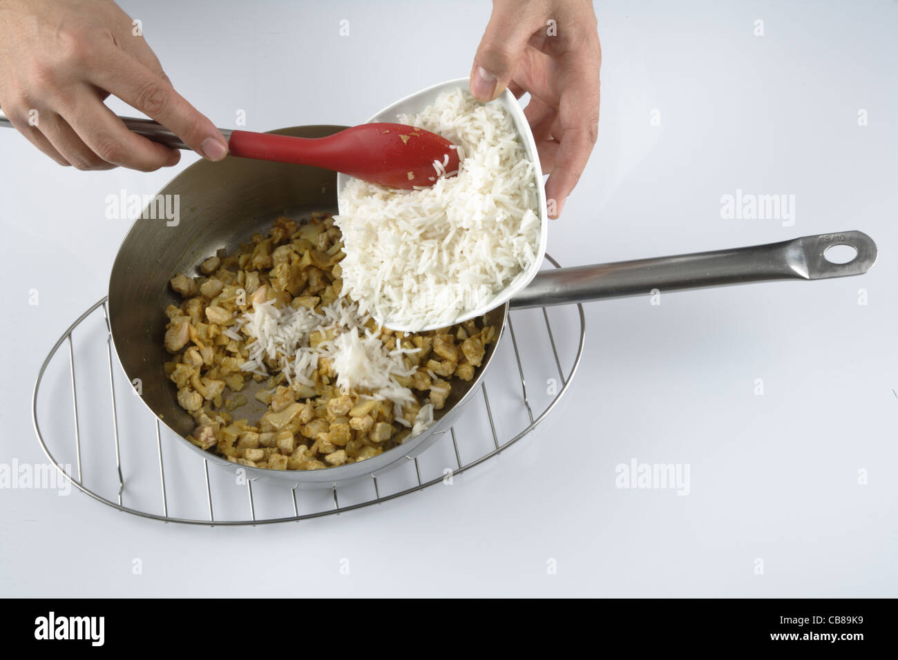 Adding rice to chicken Stock Photo - Alamy