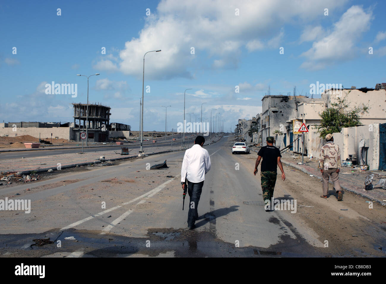 Members of Misrata militia walk through the battle ravaged streets of Sirte Stock Photo