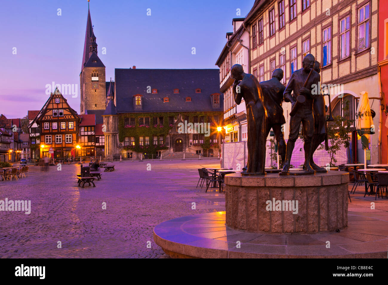Twilight in the main market place or square, the Markt, Quedlinburg, Germany with statue of Muenzenberg Musicians in foreground. Stock Photo