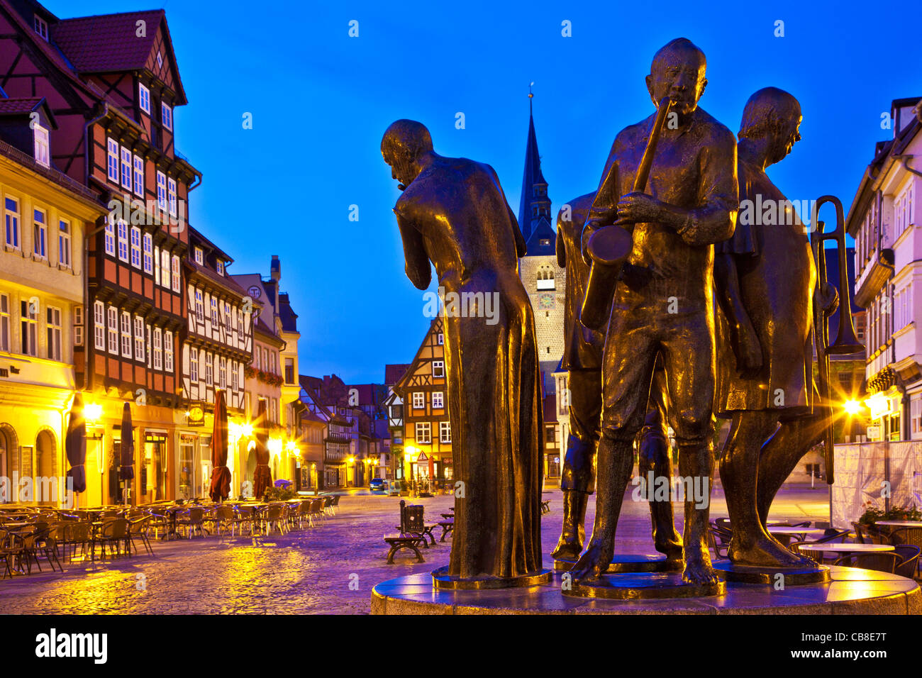 Twilight in the market place or square, the Markt, in Quedlinburg, Germany with statue of Muenzenberg Musicians in foreground. Stock Photo