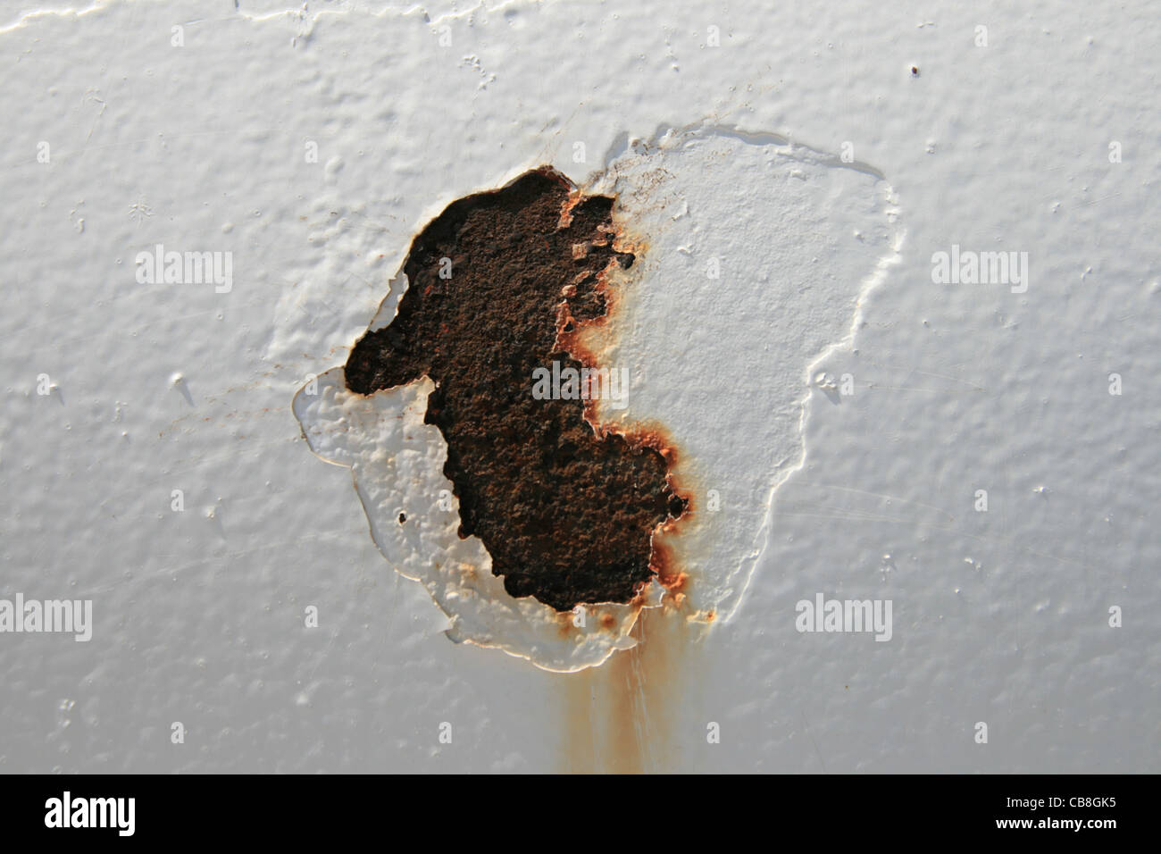peeling rust spot on a white painted steel tank Stock Photo