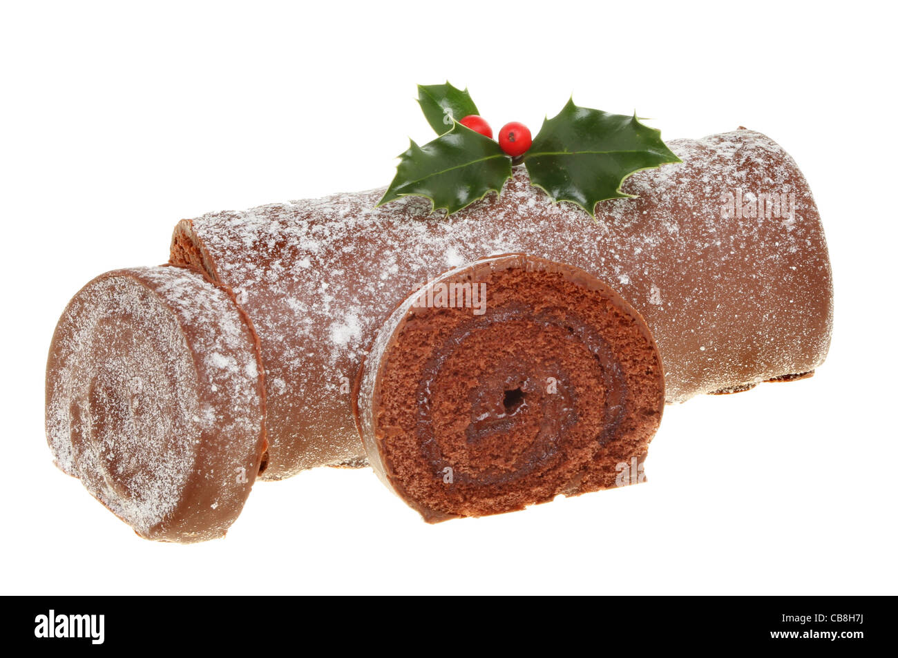 Closeup of a sliced Christmas chocolate log decorated with fresh holly isolated on white Stock Photo